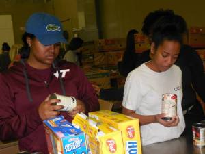 Mu Alpha members  Jessica Clanton and Desiree Turner pack meals for the Feeding the Homeless event.